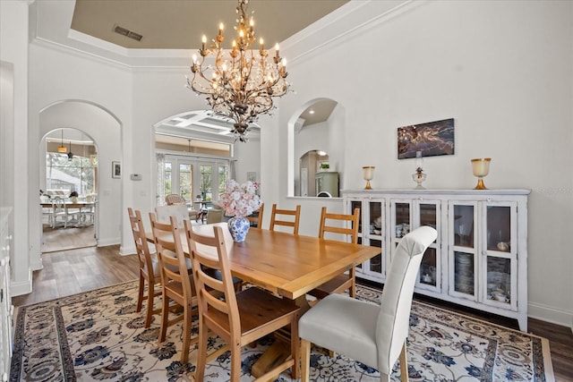10664 Emerald Chase Dr, Orlando, FL 32836 - dining area with arched walkways, visible vents, crown molding, and wood finished floors