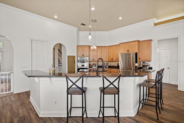 10664 Emerald Chase Dr, Orlando, FL 32836 - kitchen with stainless steel appliances, arched walkways, dark wood finished floors, and dark countertops