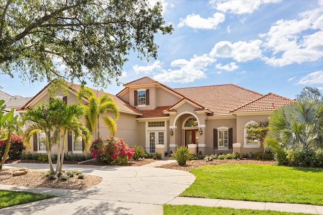 10664 Emerald Chase Dr, Orlando, FL 32836 - mediterranean / spanish home featuring a tiled roof, stucco siding, curved driveway, and a front yard