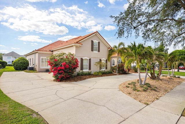 10664 Emerald Chase Dr, Orlando, FL 32836 - mediterranean / spanish house featuring cooling unit, curved driveway, stucco siding, and a tile roof