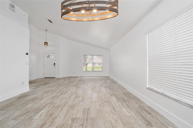 interior space featuring high vaulted ceiling, light wood finished floors, and baseboards