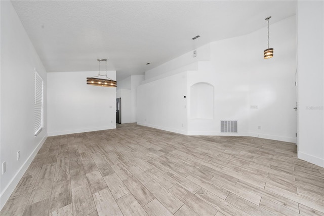 spare room featuring visible vents, baseboards, and light wood finished floors