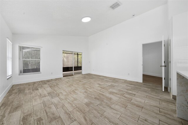 spare room with light wood-style flooring, baseboards, and visible vents