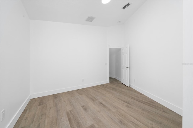 unfurnished room with light wood-style floors, baseboards, and visible vents