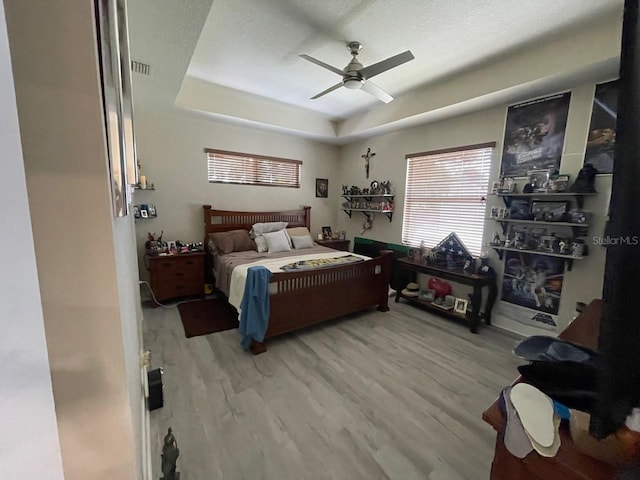 731 Triumph Dr, Sebring, FL 33872 - bedroom with wood finished floors, a tray ceiling, and ceiling fan