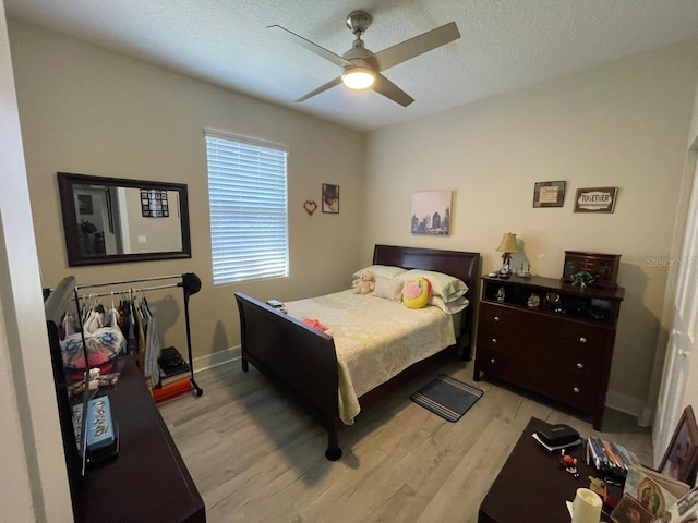 731 Triumph Dr, Sebring, FL 33872 - bedroom featuring light wood-style flooring, a ceiling fan, baseboards, and a textured ceiling