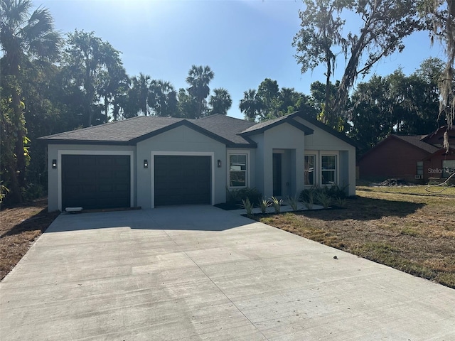 single story home featuring a front lawn, driveway, an attached garage, and stucco siding