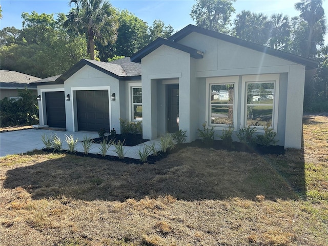 single story home featuring a garage, stucco siding, and driveway
