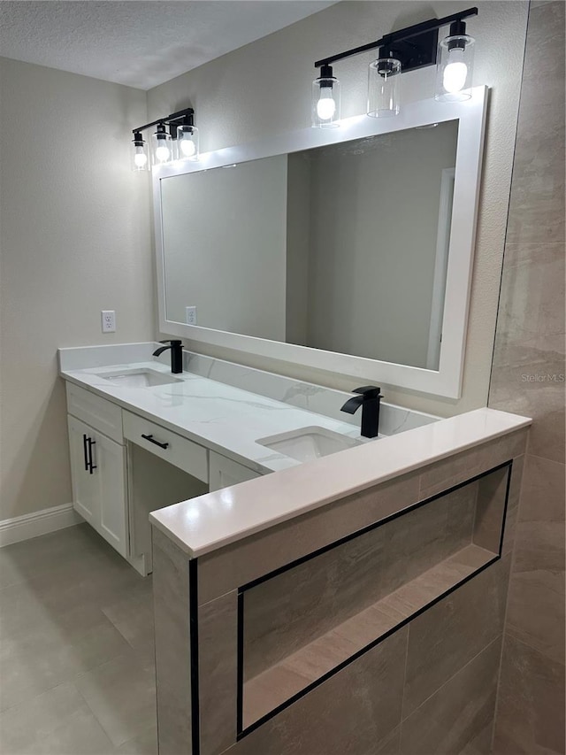 bathroom featuring double vanity, baseboards, and a sink