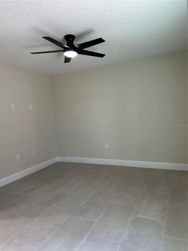 unfurnished room featuring a textured ceiling, ceiling fan, and baseboards