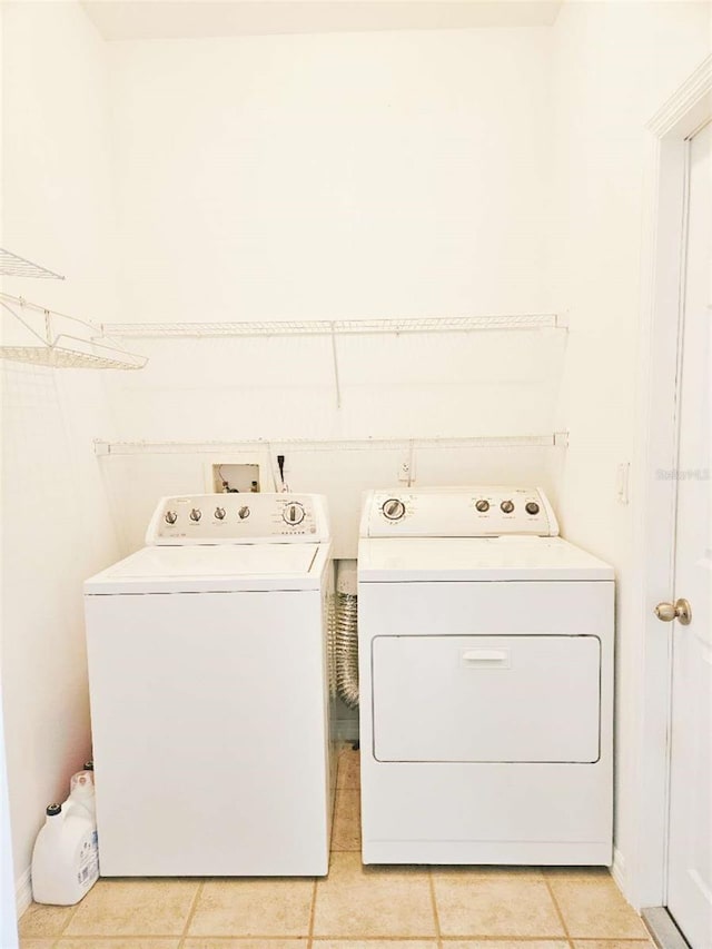 5421 Watervista Dr, Orlando, FL 32821 - clothes washing area with laundry area, washer and clothes dryer, and light tile patterned floors