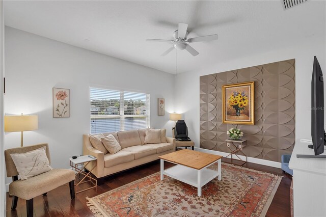 living area featuring visible vents, ceiling fan, wood finished floors, and baseboards