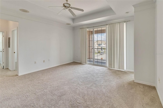unfurnished room with ceiling fan, a raised ceiling, carpet, and baseboards