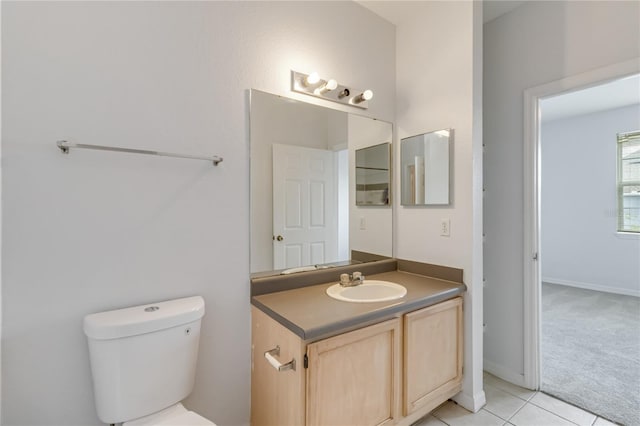 bathroom with toilet, tile patterned floors, vanity, and baseboards