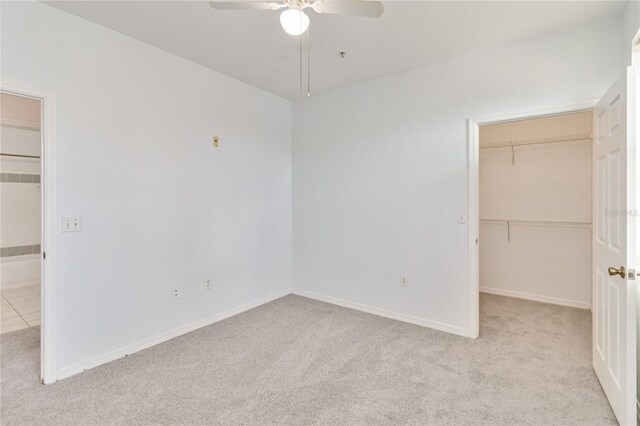 unfurnished bedroom featuring a spacious closet, a closet, and carpet floors