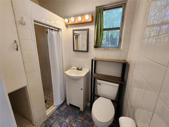 bathroom featuring a shower stall, vanity, tile patterned flooring, toilet, and tile walls