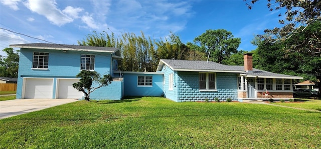 view of front facade featuring concrete driveway, a front lawn, a chimney, and an attached garage