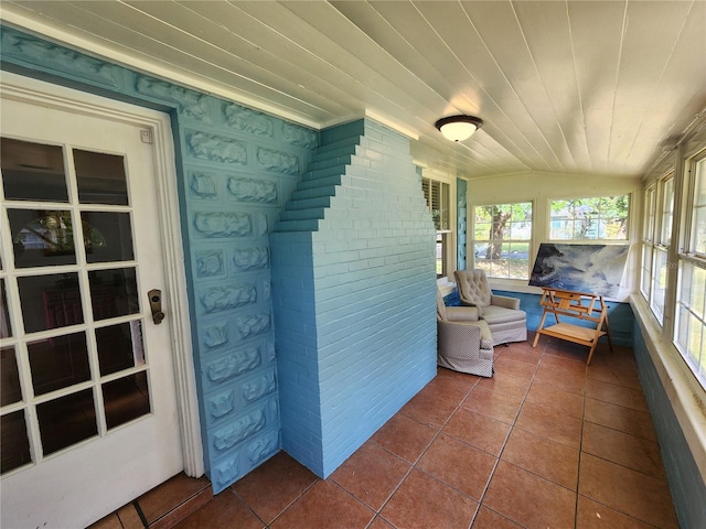 sunroom / solarium with tile patterned flooring and lofted ceiling