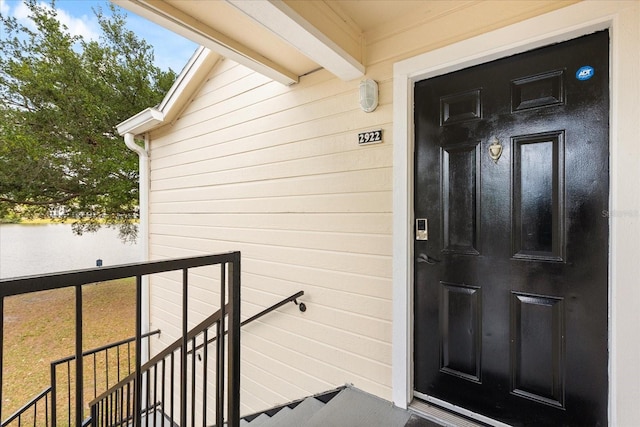 property entrance with a water view and a balcony