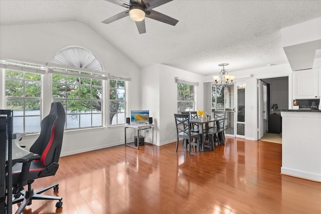 dining room featuring a healthy amount of sunlight, light wood finished floors, and ceiling fan with notable chandelier