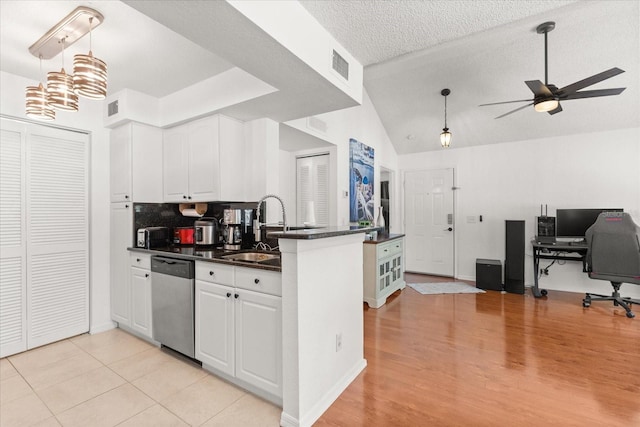 kitchen with visible vents, dishwasher, a sink, ceiling fan, and dark countertops