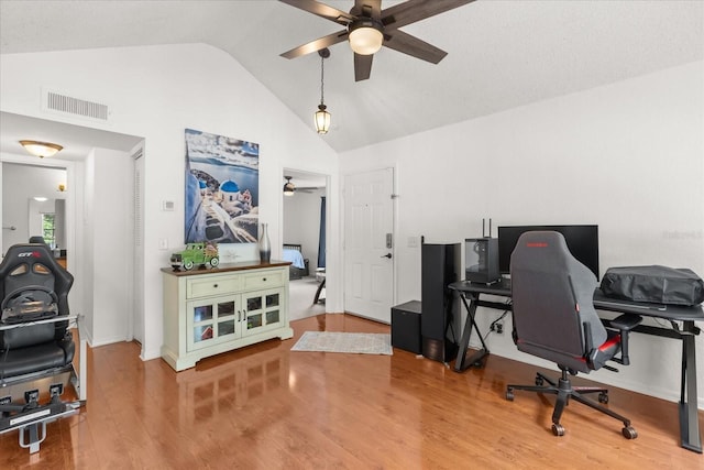 office space featuring wood finished floors, ceiling fan, visible vents, and high vaulted ceiling