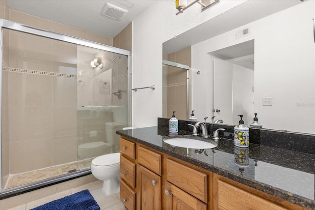 bathroom featuring visible vents, toilet, a stall shower, and vanity