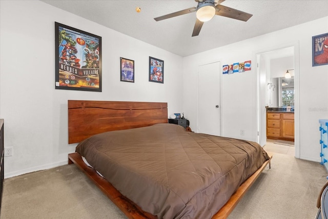 bedroom with light colored carpet, baseboards, and connected bathroom