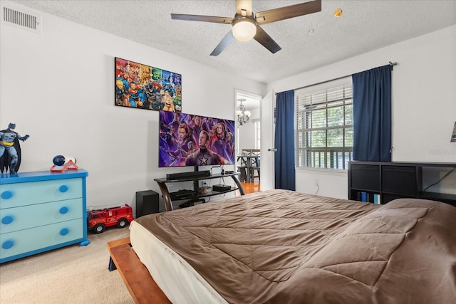 carpeted bedroom with visible vents, a textured ceiling, and ceiling fan with notable chandelier