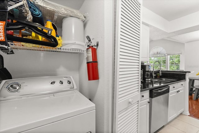 laundry area featuring washer / clothes dryer, light tile patterned floors, and a sink