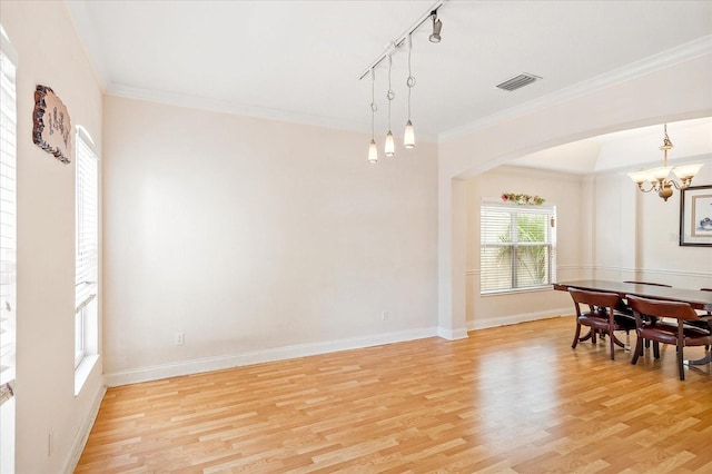 6959 Brescia Way, Orlando, FL 32819 - dining area with light wood-type flooring, visible vents, crown molding, and an inviting chandelier