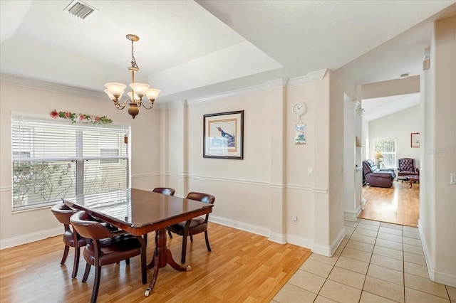 6959 Brescia Way, Orlando, FL 32819 - dining room featuring crown molding, light wood-style floors, an inviting chandelier, baseboards, and visible vents
