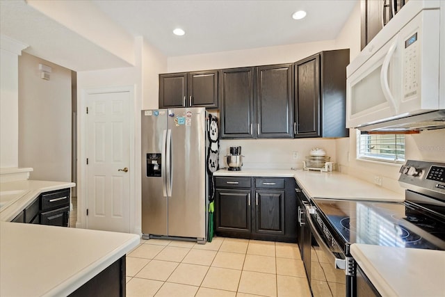 6959 Brescia Way, Orlando, FL 32819 - kitchen with stainless steel appliances, light countertops, recessed lighting, and light tile patterned floors