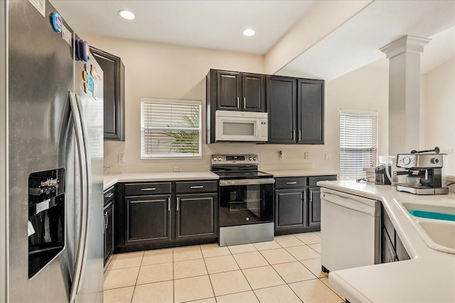 6959 Brescia Way, Orlando, FL 32819 - kitchen featuring light tile patterned floors, a wealth of natural light, appliances with stainless steel finishes, and light countertops