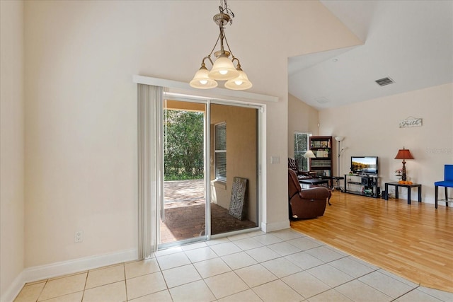 6959 Brescia Way, Orlando, FL 32819 - doorway with baseboards, visible vents, high vaulted ceiling, and light tile patterned floors