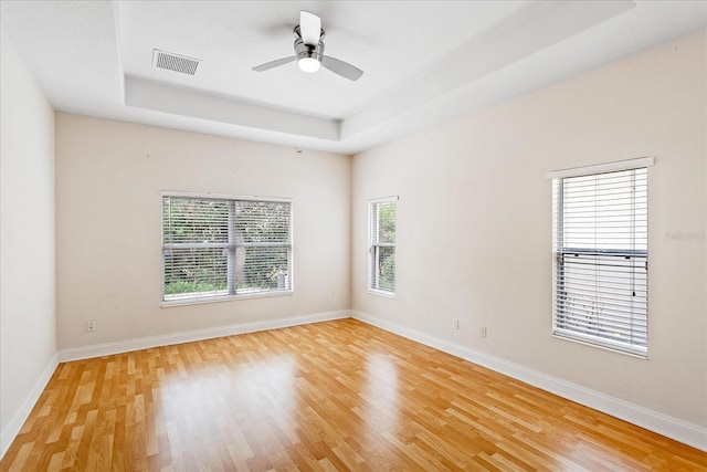 6959 Brescia Way, Orlando, FL 32819 - unfurnished room featuring light wood finished floors, a raised ceiling, visible vents, baseboards, and ceiling fan