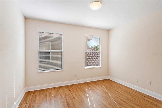 6959 Brescia Way, Orlando, FL 32819 - spare room featuring wood finished floors and baseboards