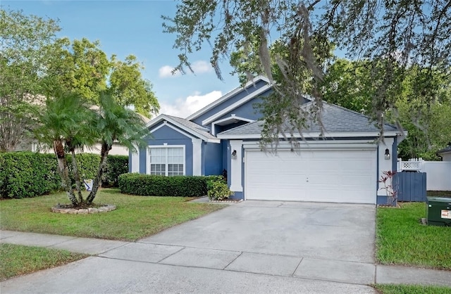 ranch-style house featuring stucco siding, fence, a front lawn, a garage, and driveway