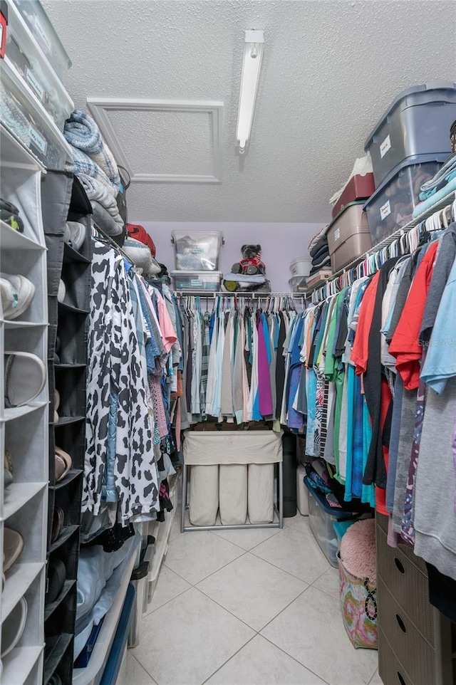 walk in closet featuring attic access and tile patterned flooring