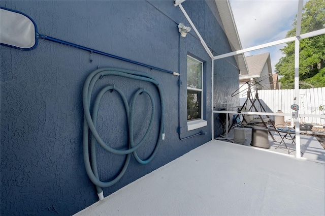 view of patio / terrace with fence and glass enclosure