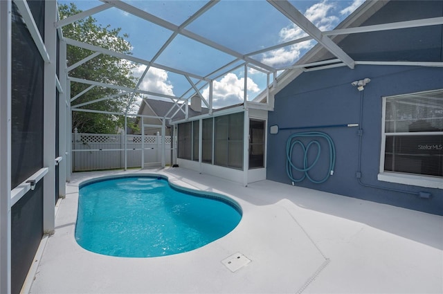 view of pool with a sunroom, glass enclosure, a patio area, fence, and a fenced in pool