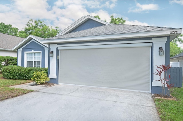 view of front facade with concrete driveway, stucco siding, a shingled roof, and a garage