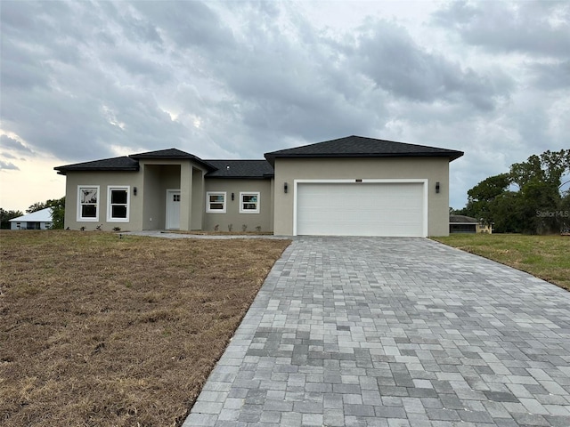 7908 Pine Glen Rd, Sebring, FL 33876 - prairie-style house featuring stucco siding, decorative driveway, an attached garage, and a front lawn