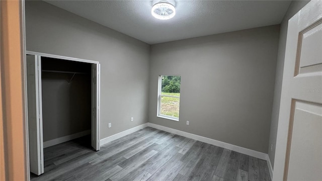 7908 Pine Glen Rd, Sebring, FL 33876 - unfurnished bedroom with wood finished floors, a closet, and a textured ceiling