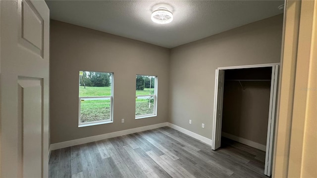 7908 Pine Glen Rd, Sebring, FL 33876 - unfurnished bedroom featuring wood finished floors, a textured ceiling, and a closet