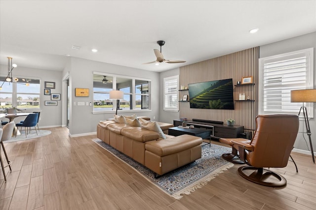 living room with baseboards, recessed lighting, light wood-type flooring, and ceiling fan
