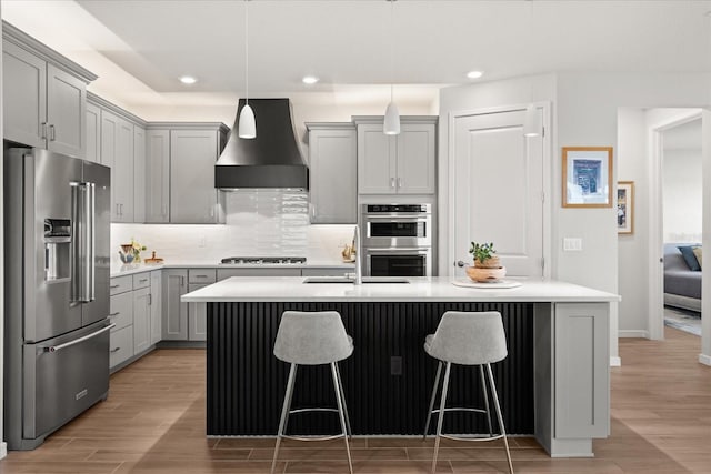 kitchen with premium range hood, stainless steel appliances, gray cabinets, and recessed lighting
