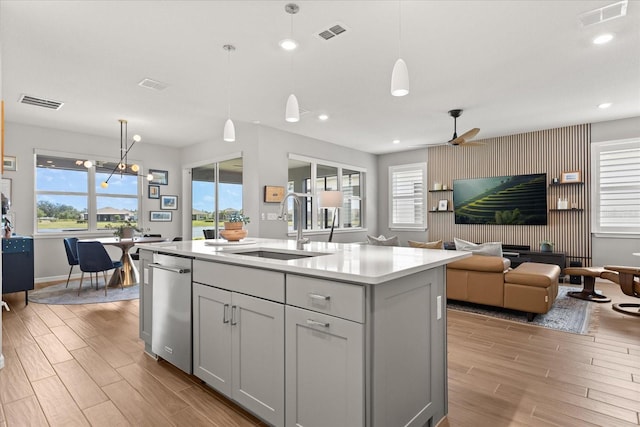 kitchen featuring light countertops, light wood finished floors, visible vents, and a sink