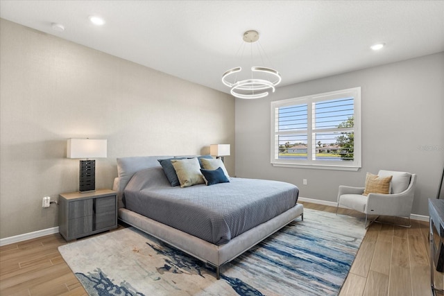 bedroom featuring light wood-style flooring, a notable chandelier, baseboards, and recessed lighting