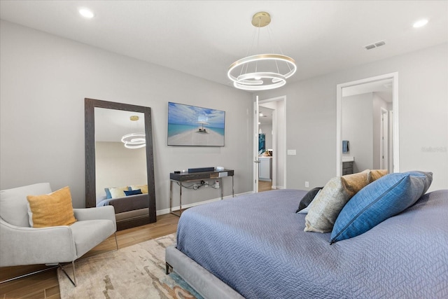 bedroom with a chandelier, recessed lighting, visible vents, and wood finished floors